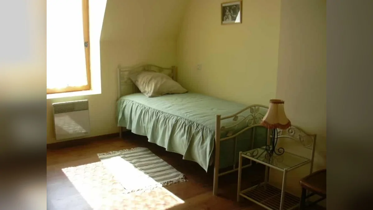 A room at La Menuiserie guesthouse, featuring a single bed and antique furniture.